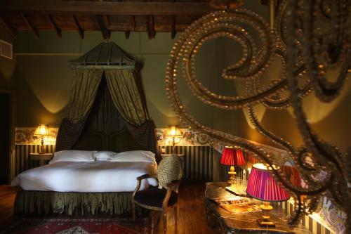 a bedroom with a bed and a table with lamps at Jardins Secrets in Nîmes