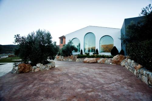 a large white building with rocks around it at Hotel & Winery Señorío de Nevada in Villamena 