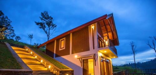 a house with lights on the stairs at night at Dowa Elegance Resort in Ella