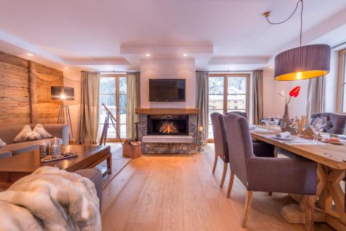 a living room with a table and a fireplace at Circle Chalets Arlberg in Lech am Arlberg