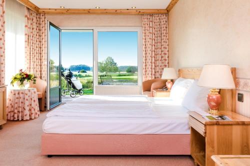 a bedroom with a large bed and a large window at GolfResort Semlin in Semlin