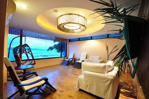 a living room with white furniture and a large window at Mithi Resort & Spa in Panglao