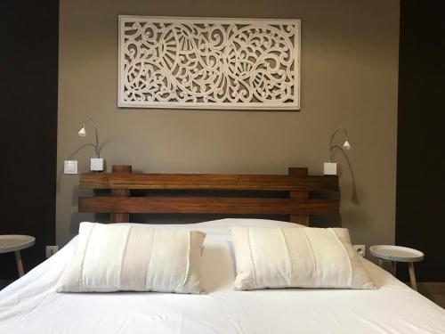 - une chambre avec un lit blanc et une photo sur le mur dans l'établissement Casa Bella, à Saint-Pierre