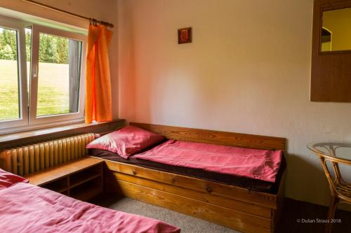 a room with two beds and a window at Penzion Pohlednička in Benecko