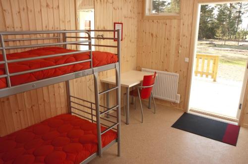 a room with two bunk beds and a table and a window at Haga Park Camping & Stugor in Mörbylånga