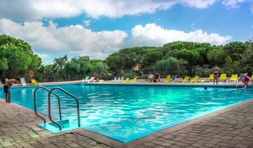 普拉塔莫納的住宿－高爾夫阿心那拉營地旅館，游泳池设有蓝色的海水和黄色的椅子