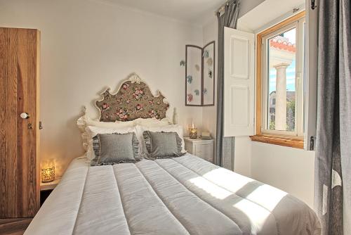 a large bed in a room with a window at NINHO SALOIO in Venda do Pinheiro