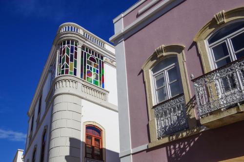 a building with stained glass windows and a balcony at Casa Margarida Azul in Silves