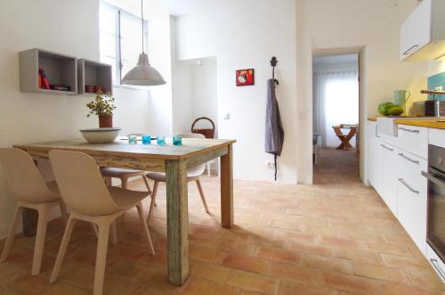 a kitchen and dining room with a wooden table and chairs at Casa Margarida Azul in Silves
