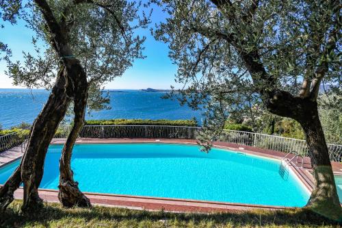 a swimming pool with a view of the ocean at La Villa Fasano in Gardone Riviera