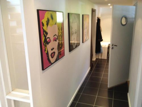 a hallway with four paintings on the walls at Country House by the lake in Hästveda