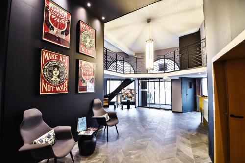 a lobby with chairs and posters on the wall at ibis Styles Dijon Central in Dijon