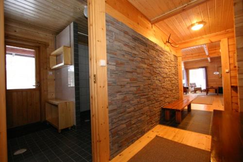 a room with a brick wall and a wooden ceiling at Mökki Lahtela in Puumala