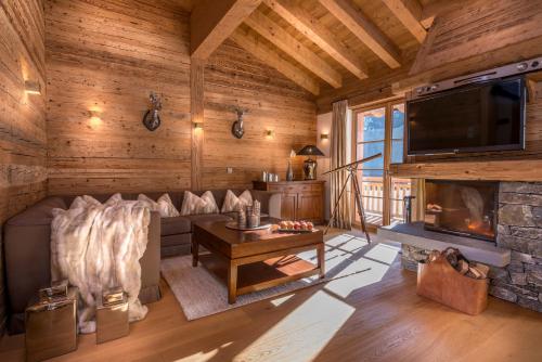 a living room with a couch and a fireplace at Circle Chalets Arlberg in Lech am Arlberg