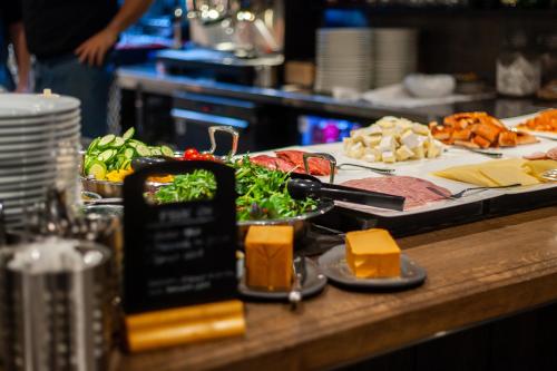 a table with a plate of food with meats and cheese at The Verdandi Hotel in Oslo