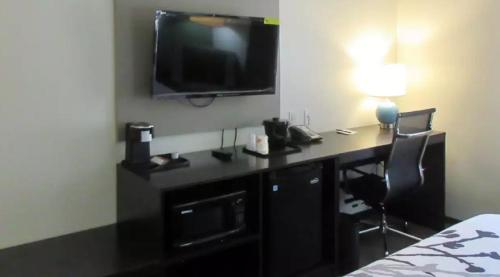 a desk with a television and a laptop on it at Klamoya Sleep Inn & Suites in Chiloquin