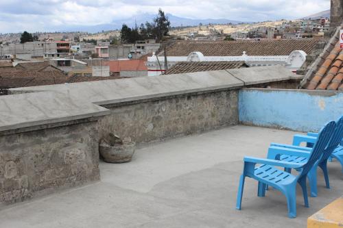 two blue chairs sitting on top of a roof at Hostal Café Tiana in Latacunga