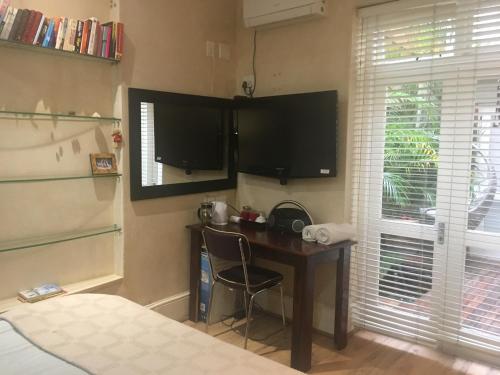 Una televisión o centro de entretenimiento en Gordons Guesthouse