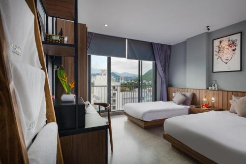 Habitación de hotel con 2 camas y ventana en Marilyn Boutique Hotel Nha Trang en Nha Trang