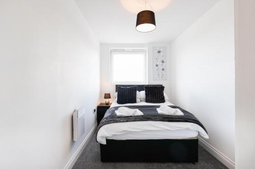 a bedroom with a black and white bed and a window at 2-bedroom apartment Mill Court, Harlow in Harlow