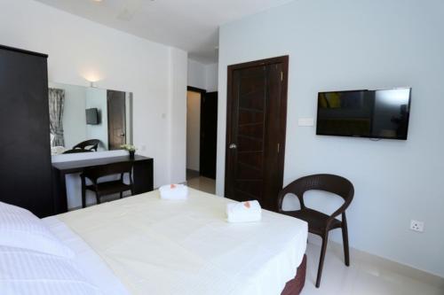 1 dormitorio con cama, escritorio y lavamanos en 5 @ Rodney Place, en Colombo