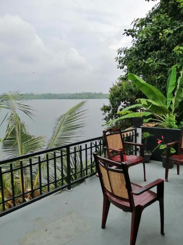 a pair of chairs sitting on a porch overlooking a lake at Hikka Lagoon in Hikkaduwa