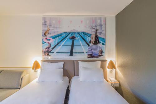 two beds in a hotel room with a pool picture on the wall at Novotel Paris Créteil Le Lac in Créteil