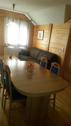 a living room with a table and a couch at Gästehaus Hartweger in Haus im Ennstal