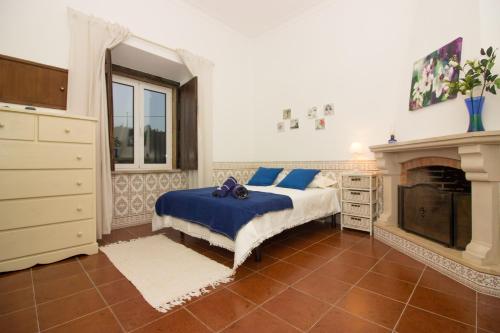 a bedroom with a bed and a fireplace at Casa da Vila Alta in Alenquer