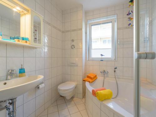 a white bathroom with a toilet and a sink at Ferienwohnung Andra in Baabe