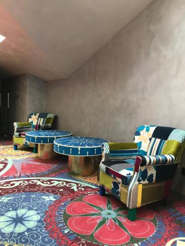 a room with chairs and a table and a rug at ArtApart Vozdvigenka in Kyiv
