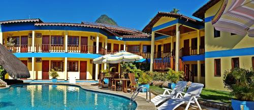 a hotel with a swimming pool in front of a building at Pousada Só Natureza in Abraão