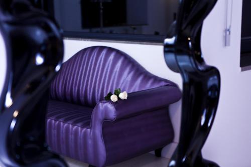 a purple chair with two white flowers on it at Hotel & Winery Señorío de Nevada in Villamena 