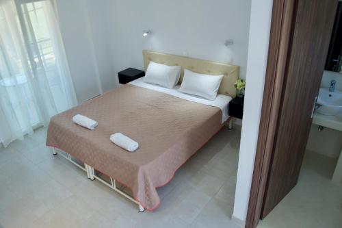 a bedroom with a large bed with two white pillows at Jessica's Studios & Apartments in Kavos