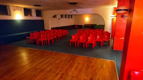 an auditorium with red chairs in a room at Hotel Holidays in Roccaraso