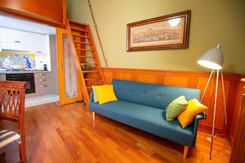 - un salon avec un canapé bleu et des oreillers jaunes dans l'établissement Sweet Toledo by Dimorra, à Naples
