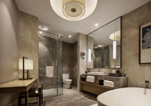 a bathroom with a tub and a toilet and a sink at Changchun Ya Tai Hotel in Changchun
