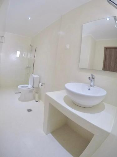 a white bathroom with a sink and a toilet at Jessica's Studios & Apartments in Kavos