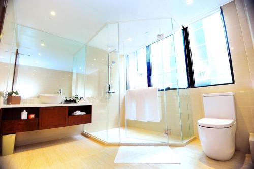 a bathroom with a glass shower and a toilet at Brighton Hotel Hong Kong in Hong Kong