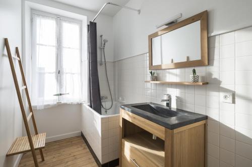 a bathroom with a sink and a shower and a mirror at L'ecume by Cocoonr in Saint-Coulomb