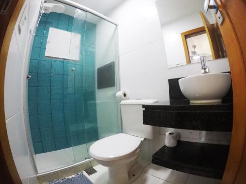 a bathroom with a toilet and a glass shower at Pousada Guapuruvu in Abraão