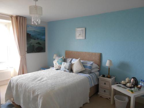 LlanaberにあるHendre Clochydd Hallの青い壁のベッドルーム1室(ベッド1台付)