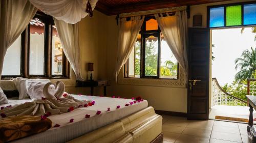 a bedroom with two beds in a room with windows at Smiles Beach Hotel in Nungwi