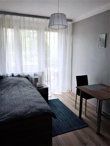 a bedroom with a bed and a desk and a table at Chrobrego 269 in Biała Podlaska