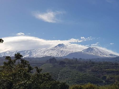 a snow covered mountain in the distance with a cloud at Etna Hotel in Giarre