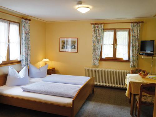 a hotel room with two beds and a television at Schnurrenhof in Seebach