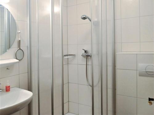 La salle de bains est pourvue d'une douche avec une porte en verre. dans l'établissement Schnurrenhof, à Seebach