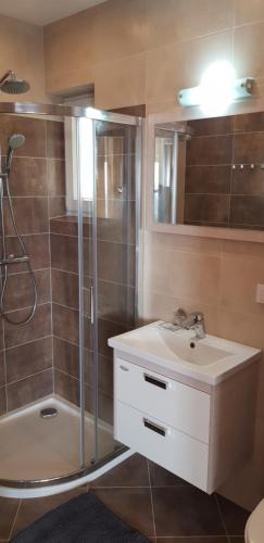 a bathroom with a shower and a sink and a tub at The Magic Sea View Apartments in Budva