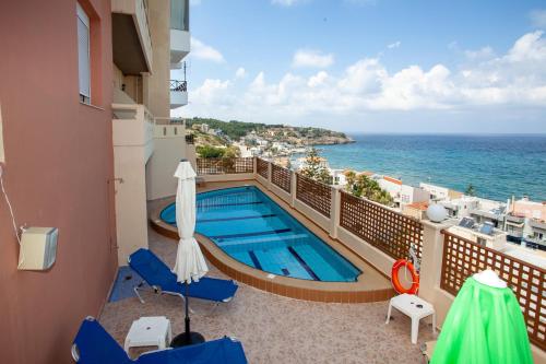 a balcony with a swimming pool and the ocean at Eliza Apartments in Rethymno Town