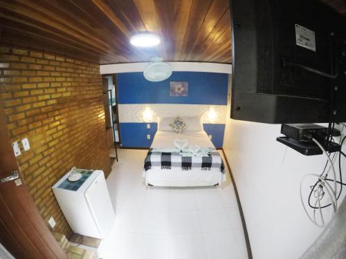 a small room with a bed and a tv at Pousada Guapuruvu in Abraão